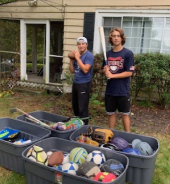 Hendrick Hudson Students Tyler Robinson and Josh Shea with boxes of donated equipment.