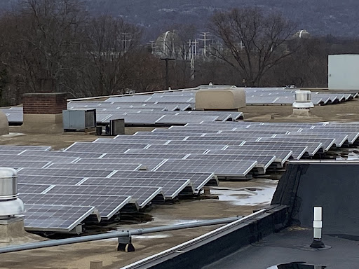 Solar panels on the roof of the high school, with the nuclear power plant Indian Point in the background. Courtesy of John May